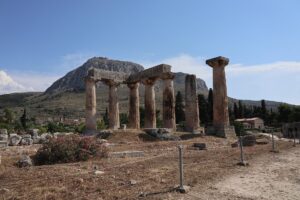 古代コリントスのアポロン神殿の柱と、背後にそびえるアクロコリントスの岩山