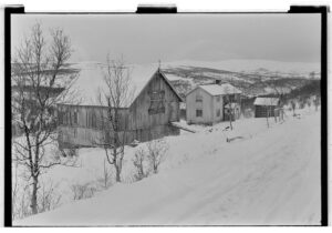 雪の農家と谷の斜面。1953年のヘスダーレン。怪光の目撃が急増する約30年前の風景を、ノルウェー国立公文書館が保存している。