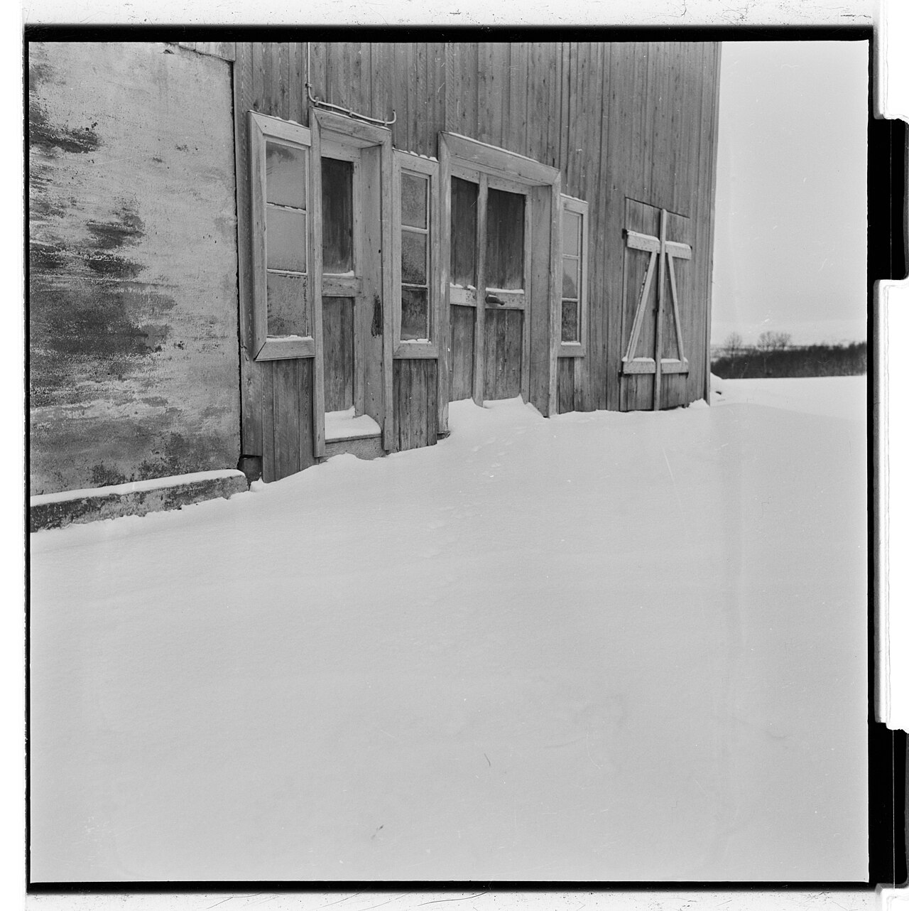 深い雪に囲まれた木造家屋。1953年撮影。1984年に閃光が報告された寝室の家とは別の写真で、谷の冬の暮らしを伝える。
