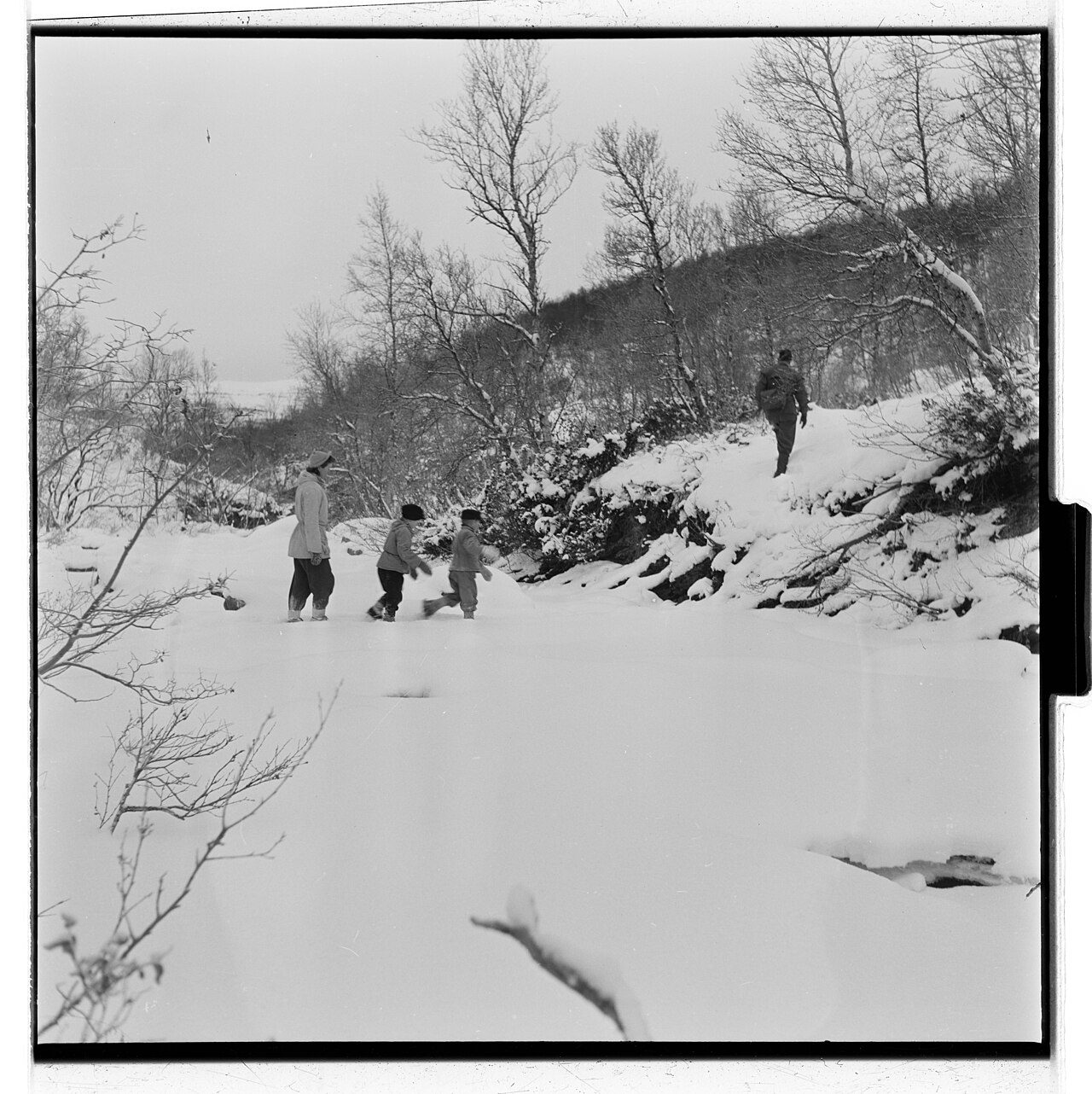 雪の谷を歩く人々。1953年撮影。1984年の調査隊を写した写真ではない。