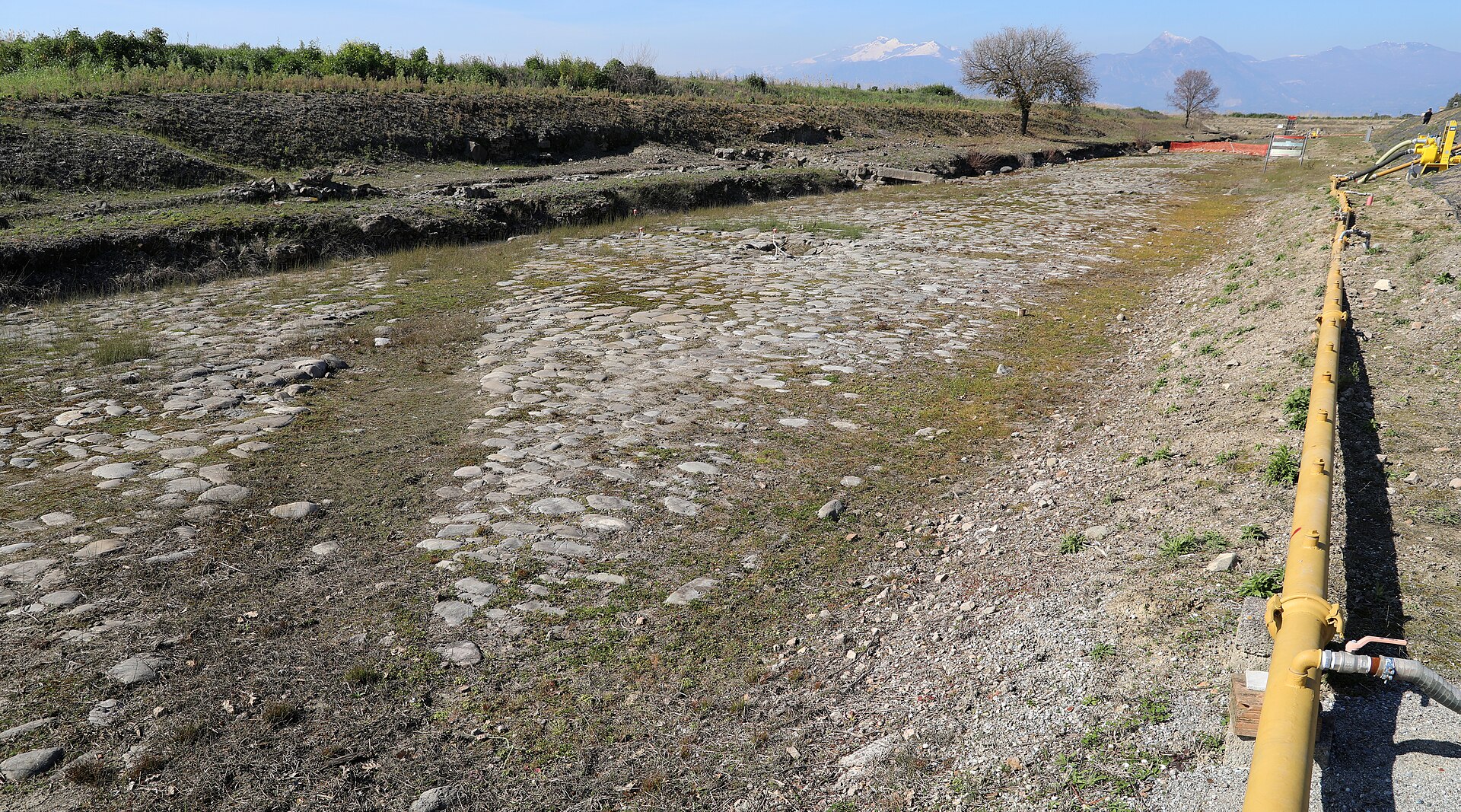 シバリス考古学公園の石畳の道と、脇を走る黄色い排水管