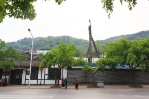 燊海井の白壁と屋根の上へ立つ木製の井戸やぐら