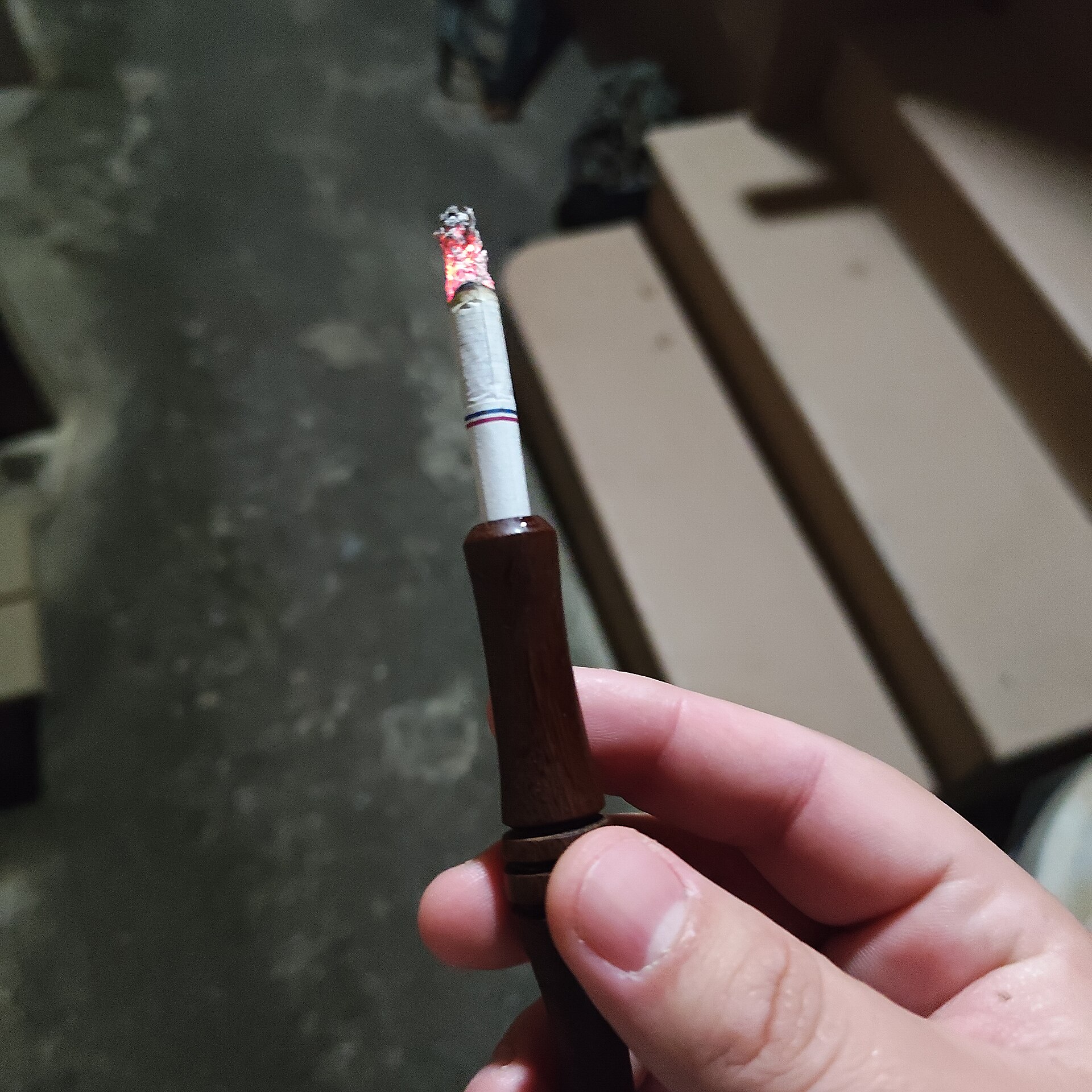 木のホルダーに差した火のついたたばこ