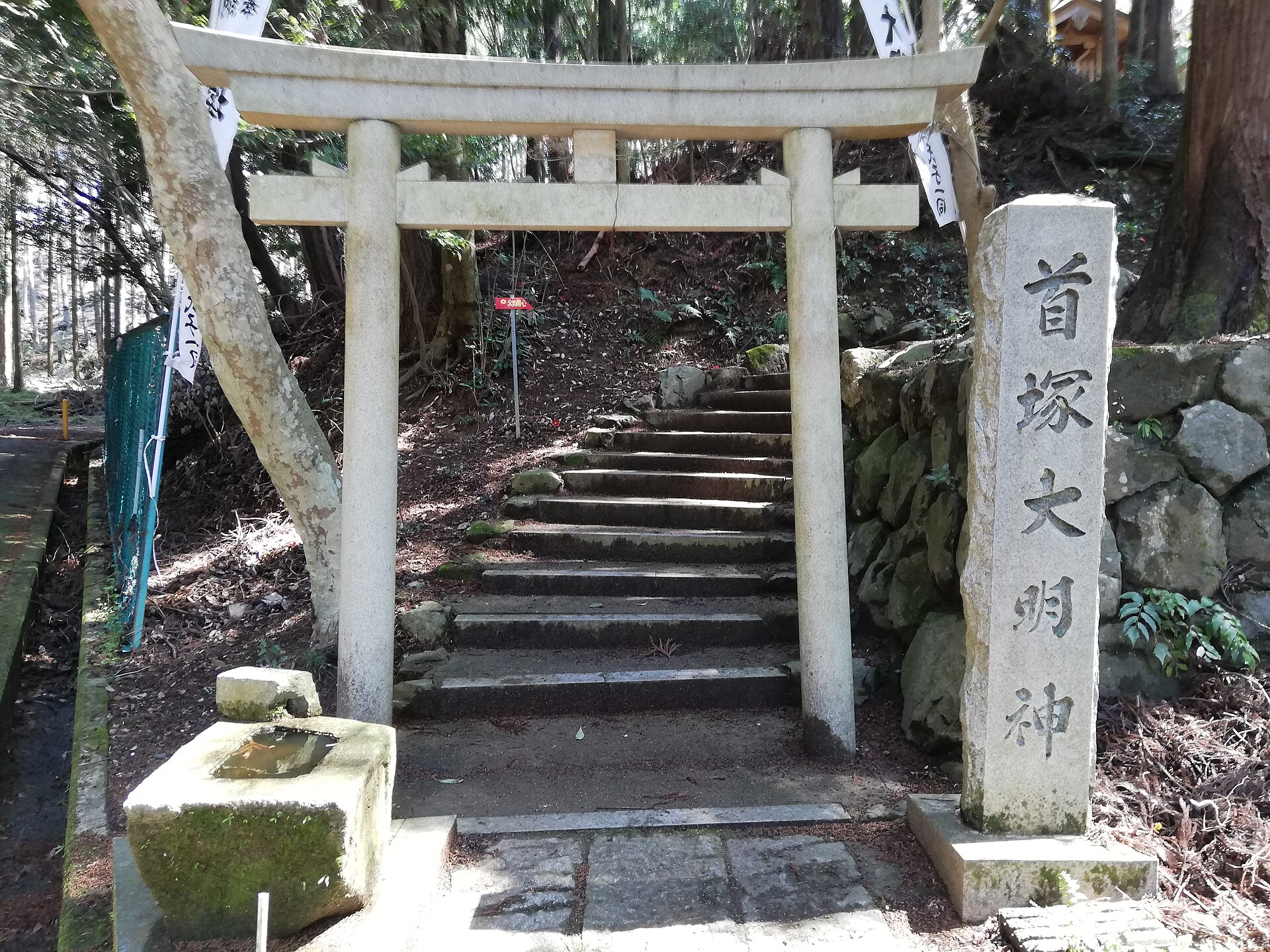 首塚大明神の鳥居と、社名を刻んだ石柱
