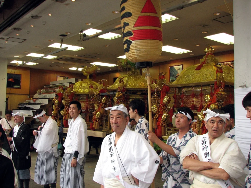 夜の祇園祭で大勢の担ぎ手が神輿を進める光景