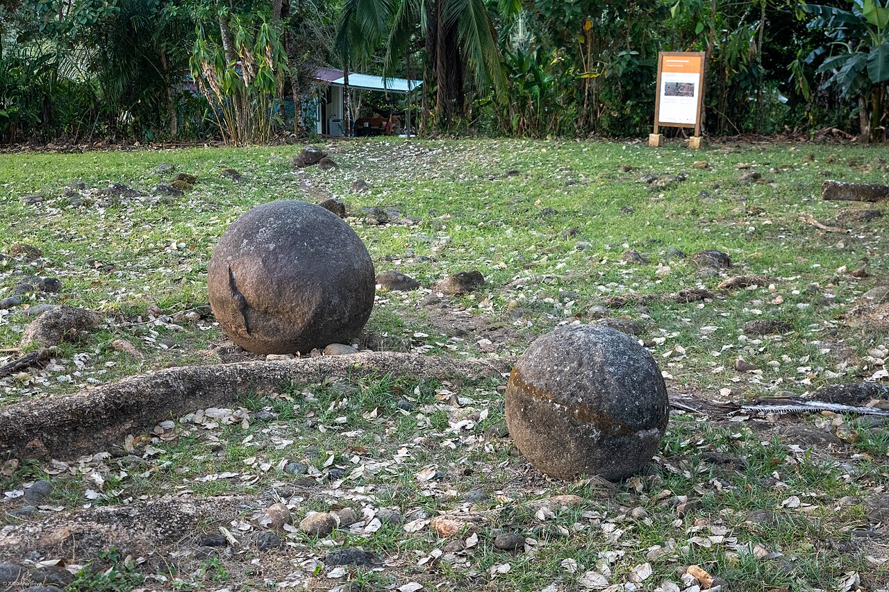 開けた草地に置かれた2つの石球。手前の1つには割れ目がある