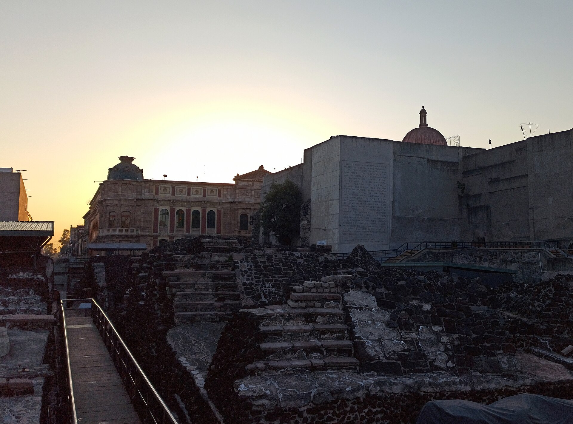 夕暮れのテンプロ・マヨール遺跡とメキシコシティ中心部の建物