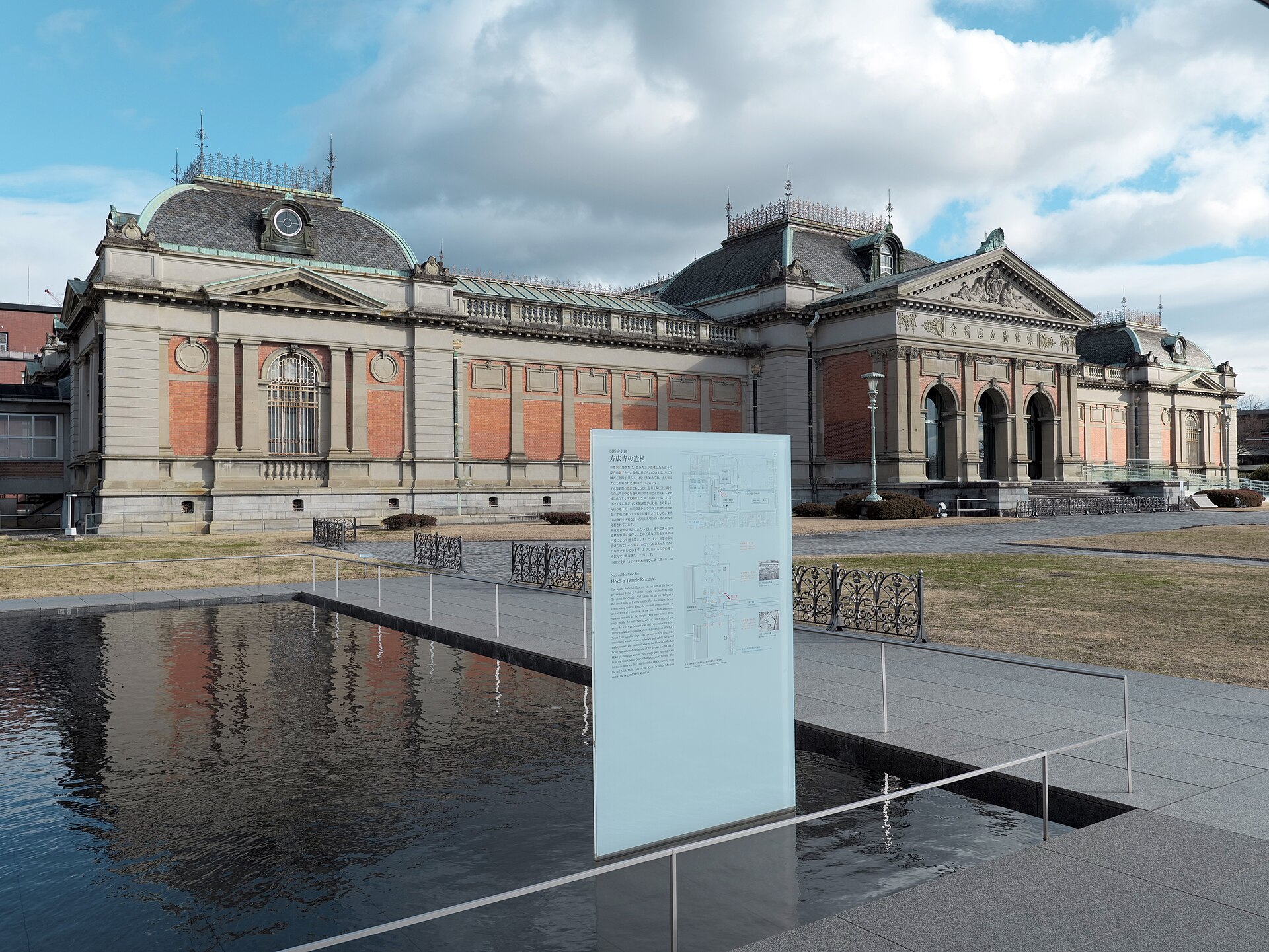 水盤に映る京都国立博物館の明治古都館。手前に解説パネルが立つ