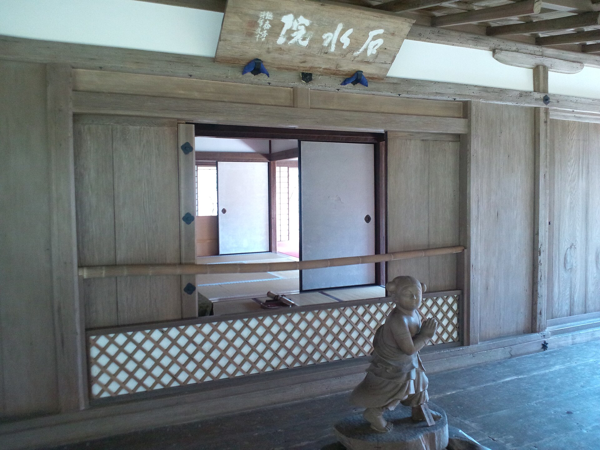 石水院の内部。『石水院』の扁額が掛かり、障子と畳の座敷、手前に善財童子像